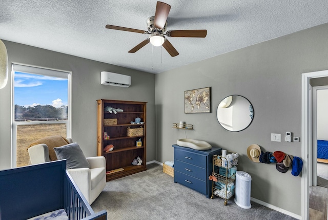 interior space with an AC wall unit, a ceiling fan, baseboards, and a textured ceiling