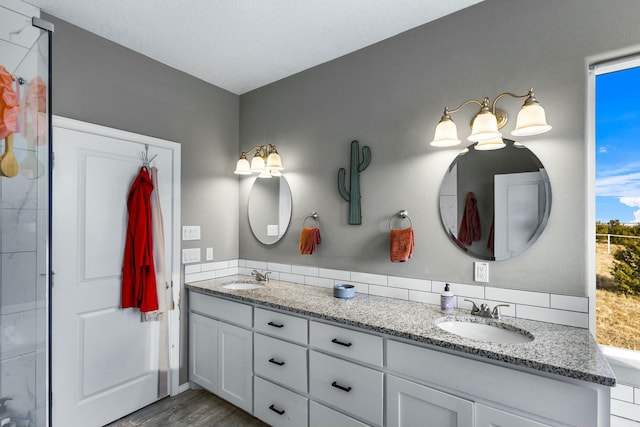 bathroom with double vanity, wood finished floors, and a sink