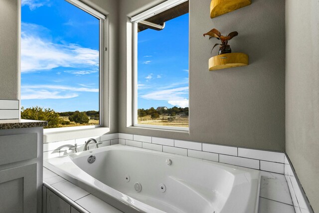 full bathroom with a jetted tub and a wealth of natural light