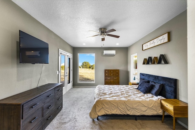 carpeted bedroom with a textured ceiling, access to exterior, ceiling fan, and a wall mounted AC