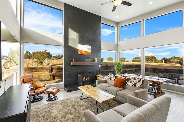 sunroom / solarium featuring a fireplace and a ceiling fan