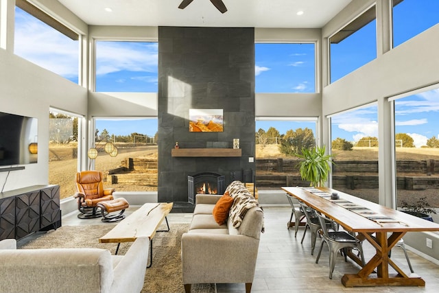 sunroom with plenty of natural light, ceiling fan, and a tile fireplace