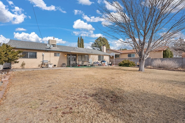 rear view of house featuring a sunroom and a yard