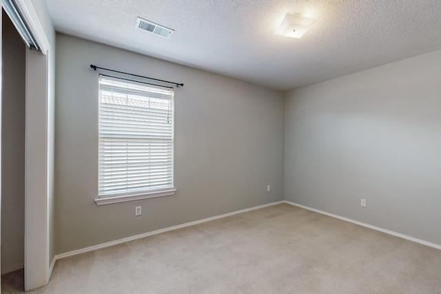 carpeted spare room with a textured ceiling