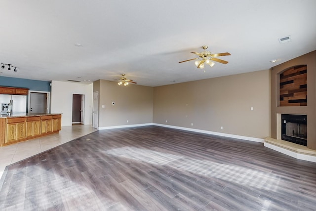 unfurnished living room with ceiling fan and light hardwood / wood-style flooring