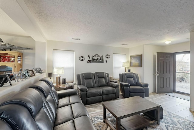 living room with a textured ceiling and visible vents