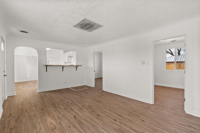 unfurnished living room featuring dark hardwood / wood-style flooring and a textured ceiling