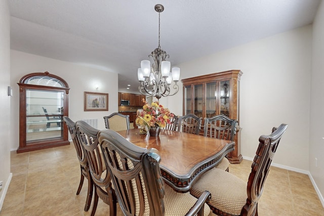 dining space with light tile patterned floors and a notable chandelier