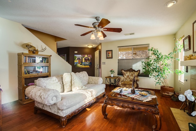 living room with ceiling fan and dark wood-type flooring