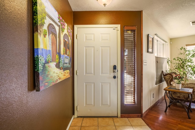 entrance foyer with plenty of natural light, light tile patterned floors, and a textured ceiling