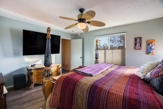 bedroom featuring a textured ceiling, ceiling fan, and dark hardwood / wood-style floors