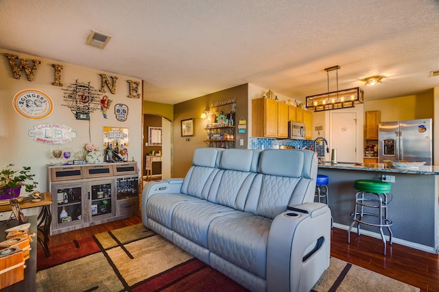 living room featuring a textured ceiling and dark hardwood / wood-style flooring