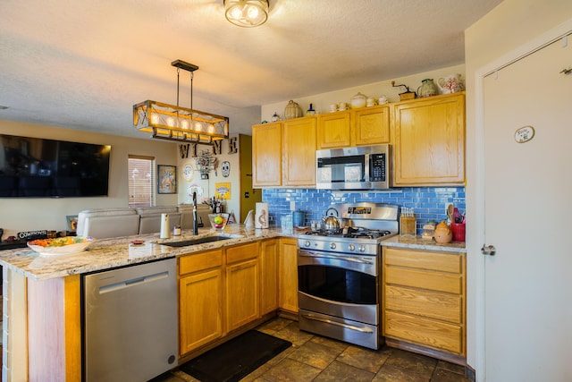 kitchen with sink, tasteful backsplash, decorative light fixtures, kitchen peninsula, and stainless steel appliances