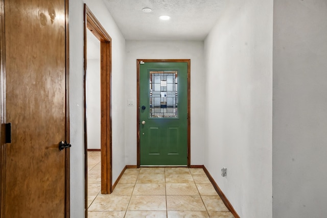 entryway featuring light tile patterned floors and a textured ceiling