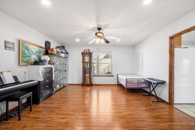 interior space with hardwood / wood-style flooring, ceiling fan, and a textured ceiling