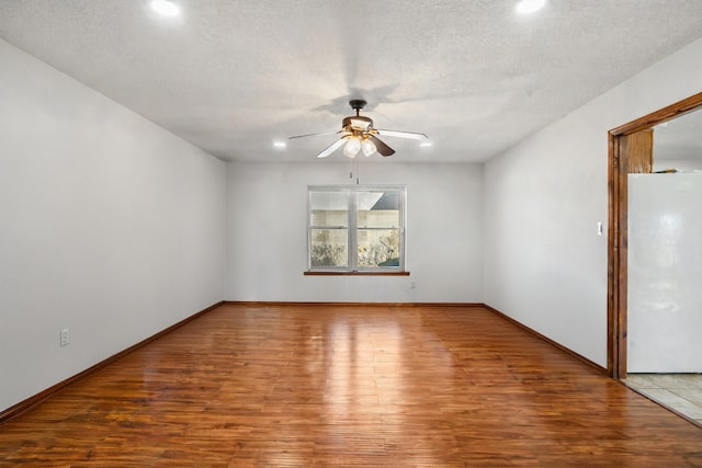 spare room featuring ceiling fan, wood-type flooring, and a textured ceiling