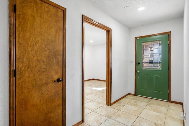 entrance foyer featuring light tile patterned floors and a textured ceiling