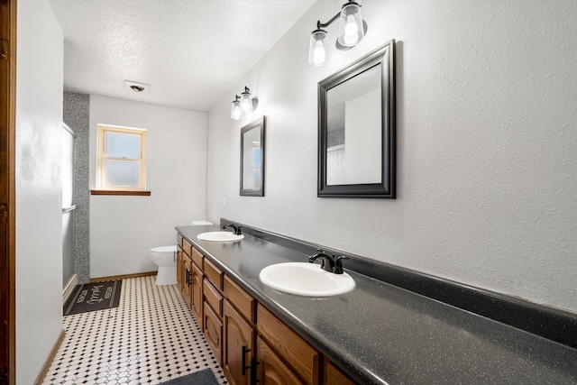 bathroom with vanity, a textured ceiling, and toilet