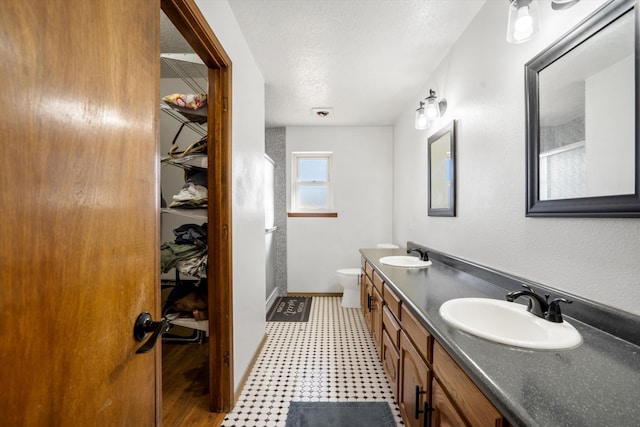 bathroom featuring vanity, toilet, and a textured ceiling