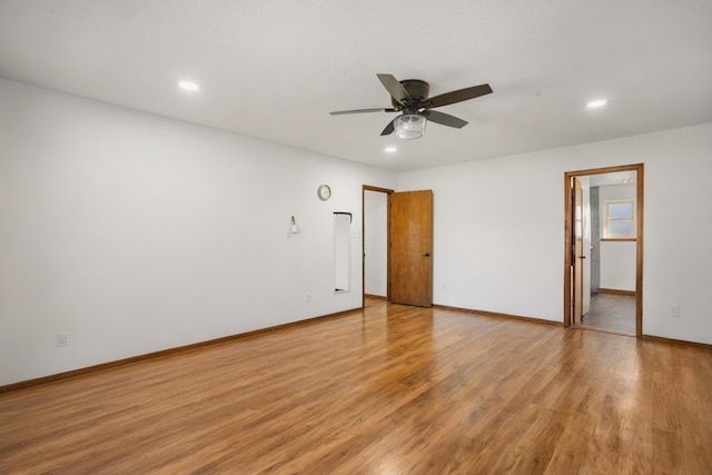 spare room with ceiling fan and light wood-type flooring