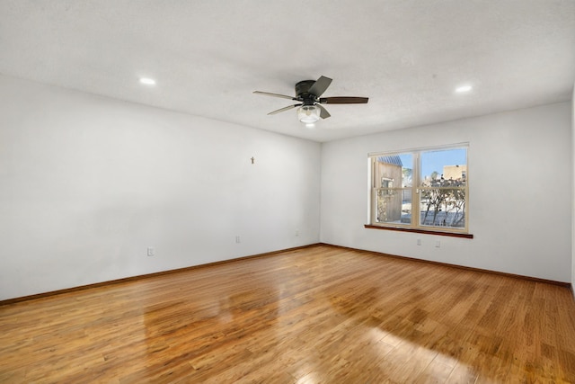 empty room featuring ceiling fan and light hardwood / wood-style flooring