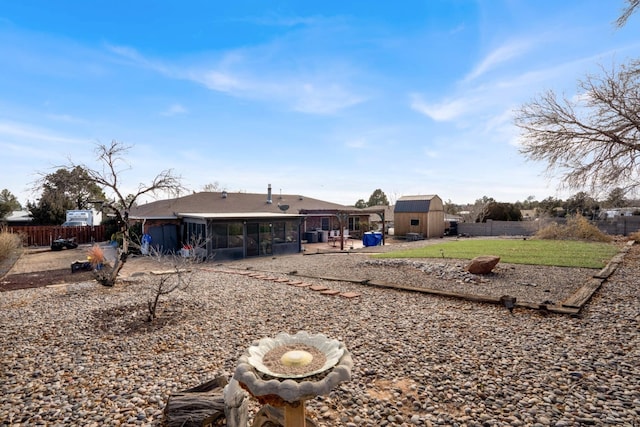 back of property with a shed and a sunroom