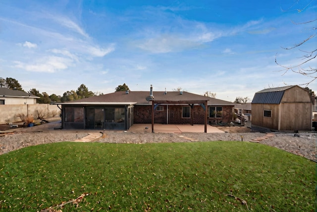 rear view of house with a sunroom, a patio area, and a lawn