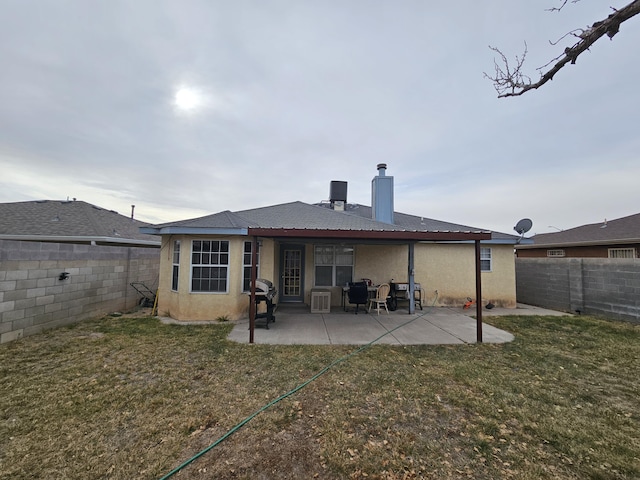 back of property with a patio area, stucco siding, a lawn, and a fenced backyard