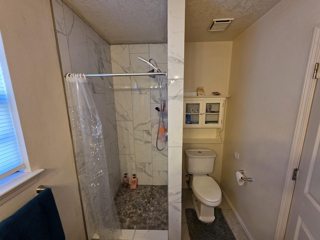 full bath with a marble finish shower, visible vents, a textured ceiling, and toilet