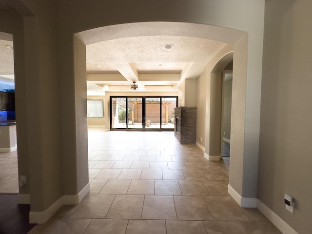 hall with beam ceiling, light tile patterned floors, and coffered ceiling