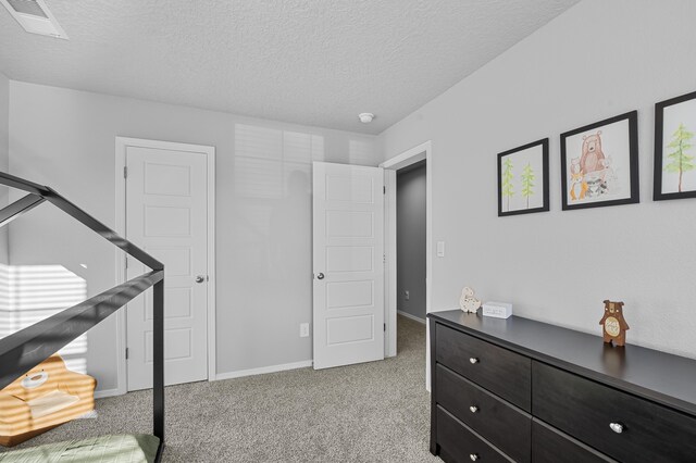 bedroom featuring carpet floors and a textured ceiling