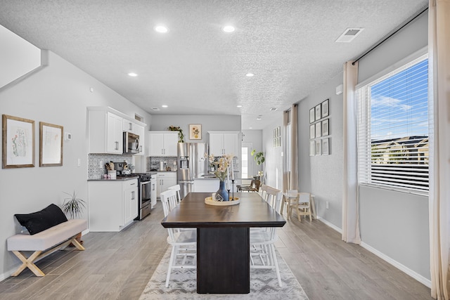 dining space featuring a textured ceiling and light hardwood / wood-style floors