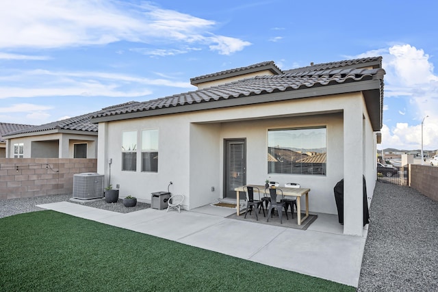 rear view of property featuring stucco siding, central AC, a fenced backyard, and a patio area