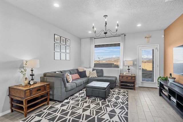 living area featuring recessed lighting, an inviting chandelier, a textured ceiling, and wood finish floors