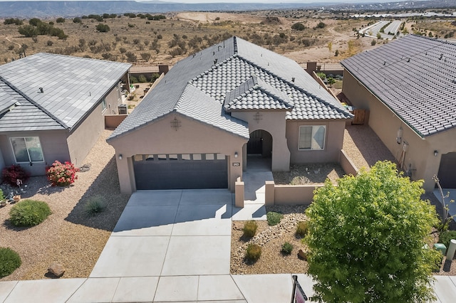 2923 Kings Canyon Loop NE, Rio Rancho, NM 87144 - view of front of home with a garage, a mountain view, driveway, stucco siding, and a tile roof