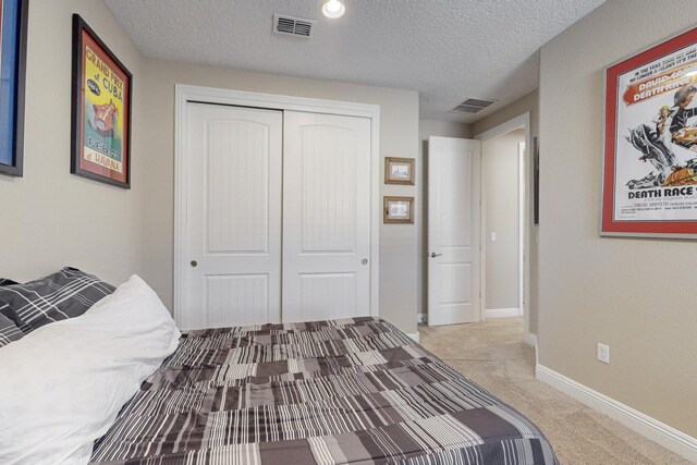 carpeted bedroom featuring a closet and a textured ceiling