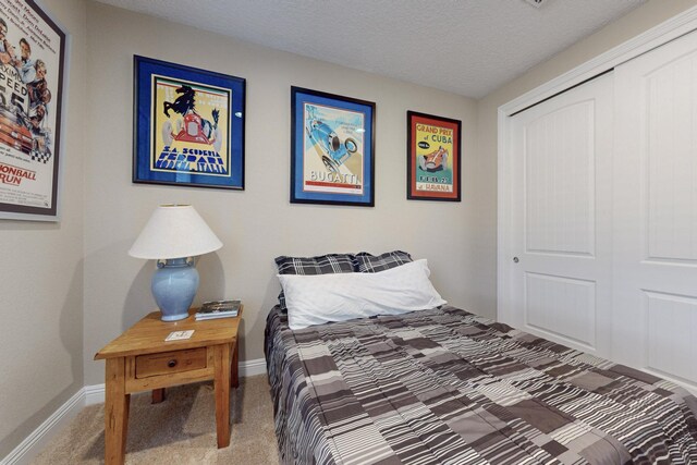 bedroom with carpet, a closet, and a textured ceiling