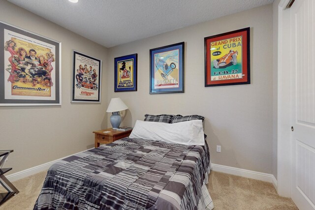 bedroom featuring light colored carpet and a textured ceiling