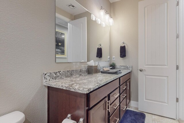 bathroom featuring vanity, tile patterned flooring, and toilet