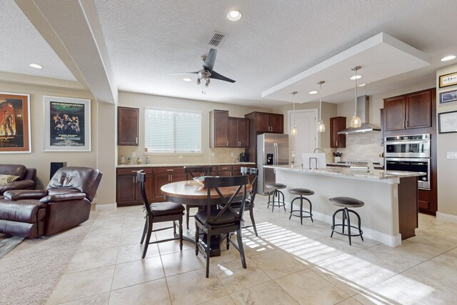 dining space with light tile patterned flooring, a textured ceiling, and ceiling fan