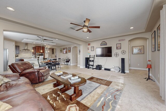 living room featuring ceiling fan and a textured ceiling