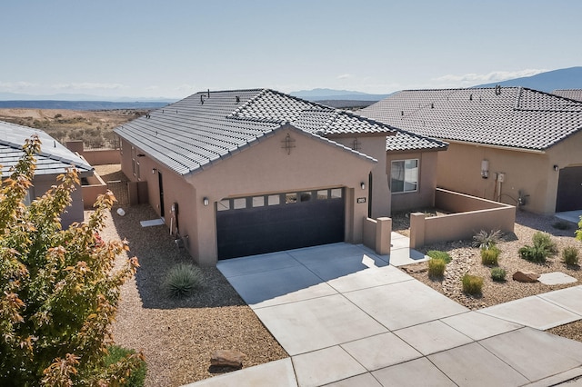 2923 Kings Canyon Loop NE, Rio Rancho, NM 87144 - view of front of home featuring stucco siding, an attached garage, driveway, and a mountain view