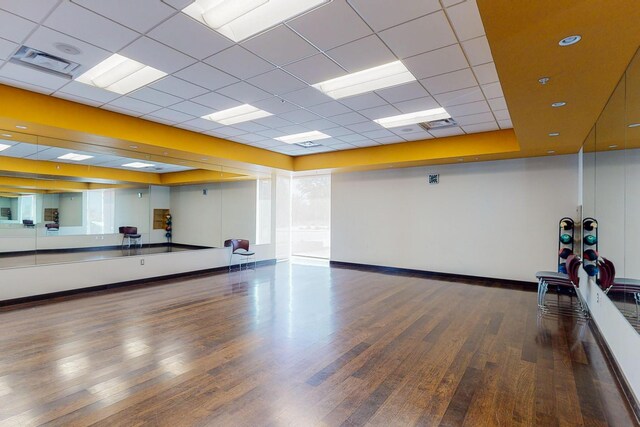 workout room featuring a tray ceiling, dark hardwood / wood-style flooring, and a drop ceiling