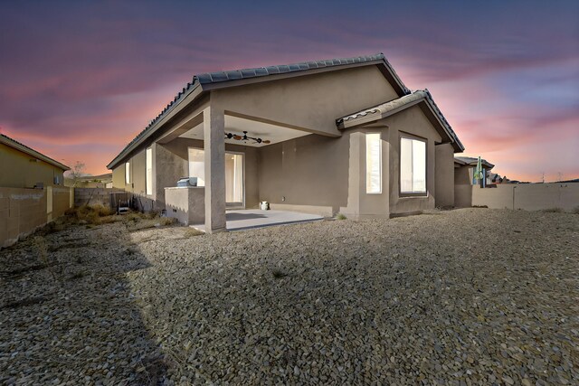 back house at dusk with a patio