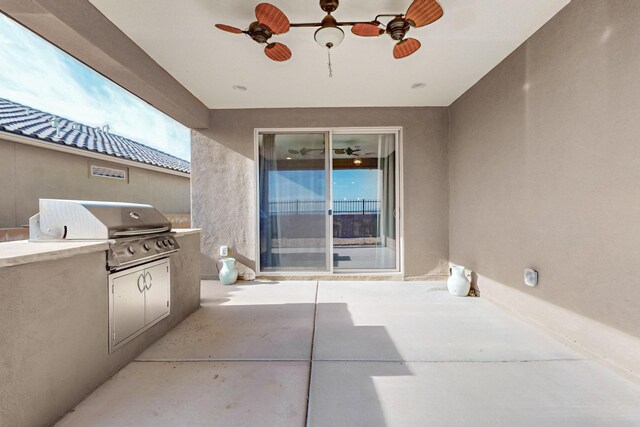 view of patio with area for grilling, ceiling fan, and an outdoor kitchen