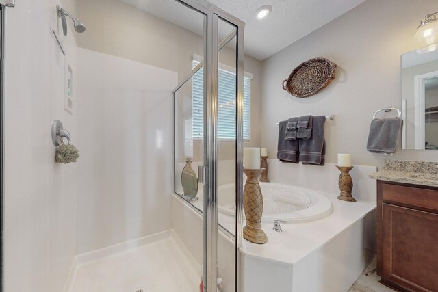 bathroom featuring independent shower and bath, vanity, and a textured ceiling