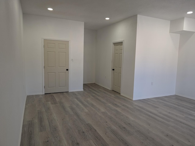 empty room featuring recessed lighting, baseboards, and wood finished floors