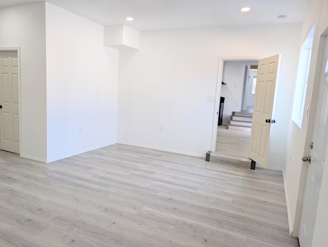 140 65th St NW, Albuquerque, NM 87105 - empty room with light wood-type flooring, recessed lighting, baseboards, a smoke detector, and stairs
