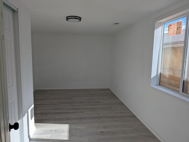 empty room featuring visible vents and wood finished floors