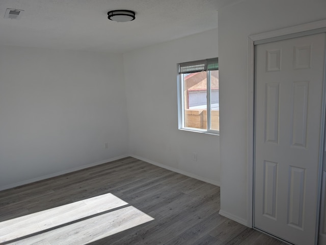 spare room featuring wood finished floors and baseboards